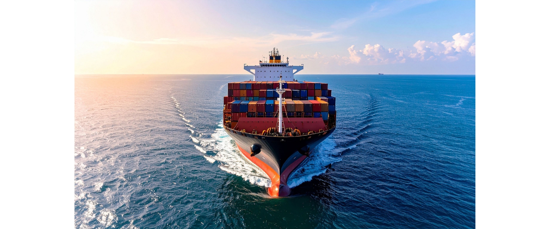 Container ship sailing on the open ocean at sunset